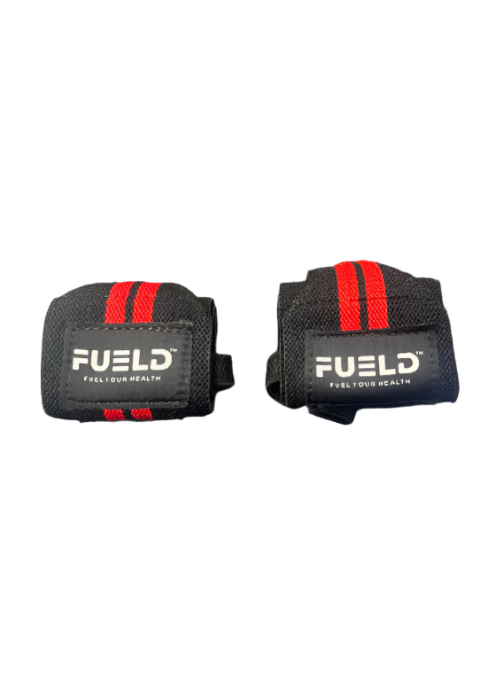 Two black wrist wraps with red straps and 'FUELD' branding on a metallic surface.